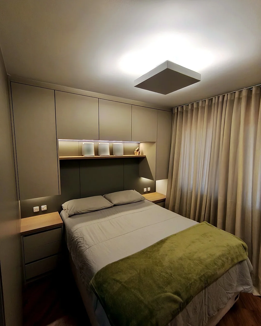 Quarto planejado pela Metri Marcenaria, com marcenaria envolvendo a cabeceira e iluminação embutida